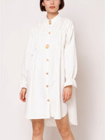 Front view of loose white top with  golden buttons, long sleeves, Semi-Stretch Fabric, 100% Polyester